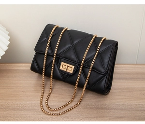 Detailed view of black quilted crossbody bag with gold chain strap and square lock
