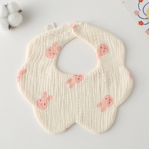 Detail of flower-shaped cream cotton baby bib with pink rabbit print and snap button