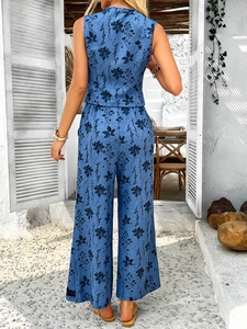 Détail du haut à fleurs bohème bleu et du pantalon large vus de l'arrière de l'ensemble