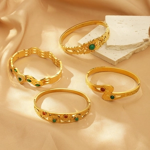 Vintage gold evil eye bangles set with colorful gemstones on a silk background