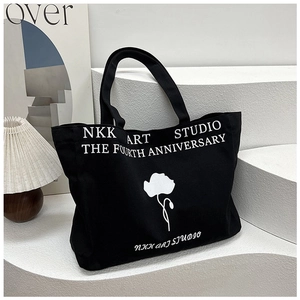 Minimalist black canvas tote bag with white flower print and NKK ART STUDIO text