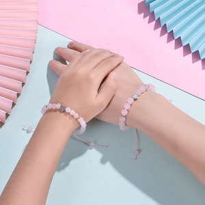 Detail of two pink zebra stone bead bracelets with silver hearts on a model's wrist