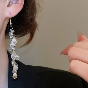 Close-up of sparkling silver tassel earrings with diamond drops for elegant look