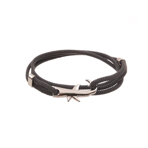 Close-up of a dark grey woven rope bracelet with a silver shark-shaped metal clasp