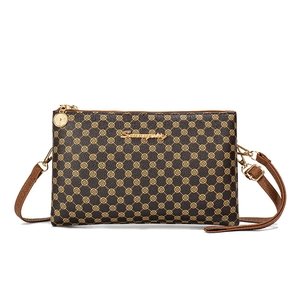 Brown leather crossbody bag with gold clover print and double zipper closure for women