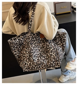 Leopard print canvas tote bag with wide straps shown in a modern interior setting