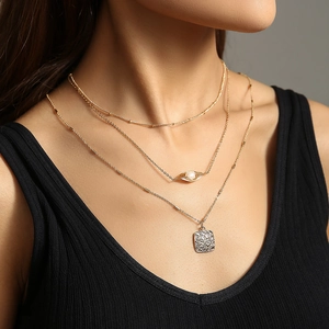 Multi-layer gold necklace with natural stone, pearl accent, and hammered square pendant