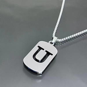 Macro view of silver titanium steel necklace featuring a hollow rectangular U letter pendant