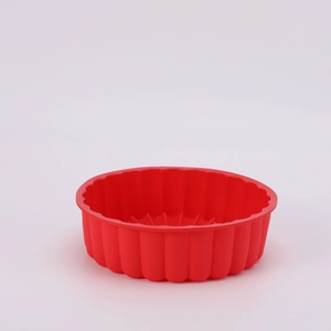 Detailed view of red silicone sunflower cake mold showing wavy texture and round shape