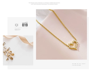 Detailed view of hollow heart pendant with white zircon stones on a gold chain