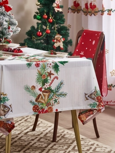 Detalle de mantel navideño con motivos festivos de campanas y jengibre sobre tela blanca
