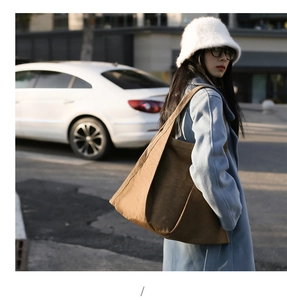 Brown nylon tote bag worn by a model in a casual street style for daily commute