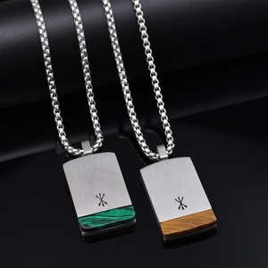 Detail of stainless steel pendants with malachite and tiger eye insets on box chains