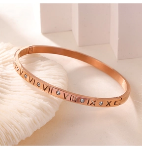 Macro shot of rose gold titanium bracelet with Roman numerals and diamond accents