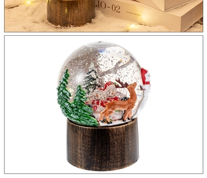 Détail d'une boule à neige de Noël avec Père Noël et renne sous une lumière chaude