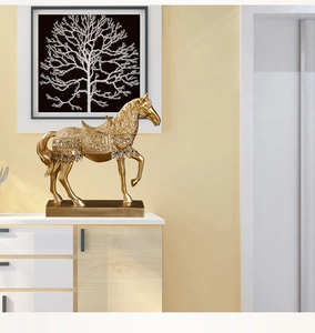 Detailed view of a luxury golden horse sculpture with blue gemstone accents on a cabinet