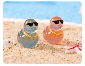 Close-up of pink and grey luminous resin ducks with sunglasses for DIY terrarium