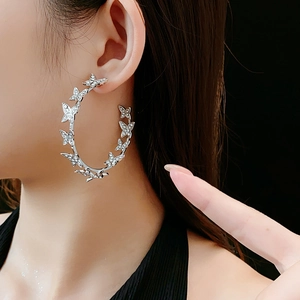 Gros plan d'un mannequin portant des créoles papillon scintillantes avec strass en argent