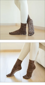 Detail of brown knitted yoga socks with white anti-slip dots on the sole for better grip