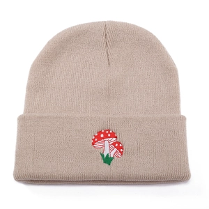 Unisex beige knit beanie featuring red mushroom embroidery on a white background