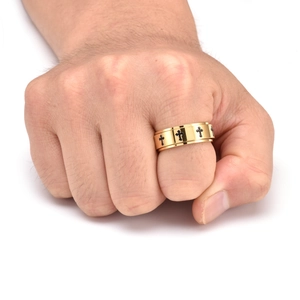 Close-up of golden stainless steel spinner ring with black crosses on male hand