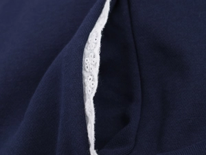 Détail du tissu en maille bleu marine avec dentelle blanche et coutures précises