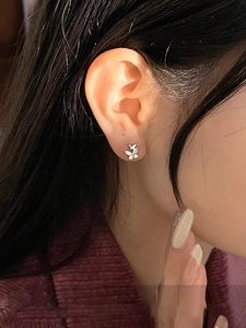 Close-up of minimalist silver butterfly stud earrings with sparkling cubic zirconia inlay