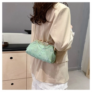 Detailed shot of light green lace shell bag with 3D floral embroidery and gold chain