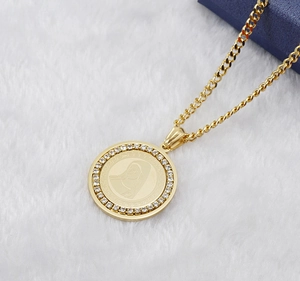Macro shot of 18K gold plated necklace with iced-out medallion and religious carving