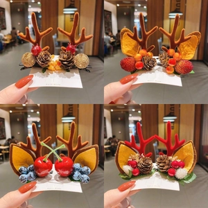 Close-up of handmade Christmas hair clips featuring antlers, berries and pine cones