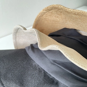 Dettaglio cappello da sole in lino beige con trama in fibra naturale e tesa a onde tessuta