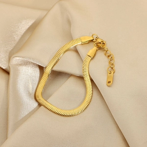 Elegant 18K gold plated stainless steel snake chain bracelet on champagne silk fabric