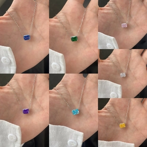 Vue macro des colliers en pierres carrées en sept couleurs avec sertissage à quatre griffes