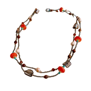 Bohemian multilayer necklace with orange, turquoise, and wooden beads on a white background