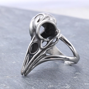 Vintage silver raven skull ring for men with punk gothic style on stone background