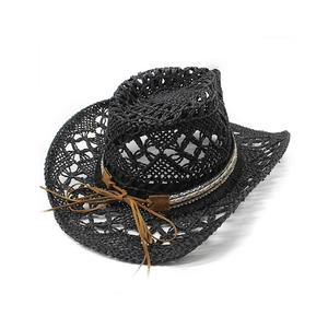 Détail d'un chapeau de cowboy en paille noire avec ruban ethnique perlé et tissage