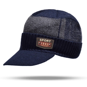 Detail of winter knit peak hat showing navy and grey stitching with sport leather patch
