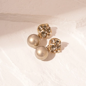 Macro shot of vintage gold earrings with champagne faux pearls and grey crystals