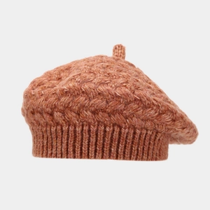 Close-up of caramel knitted beret showing thick wool texture and ribbed edge detail