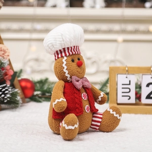 Large plush gingerbread man doll with a red knit vest and white chef hat for Christmas decor