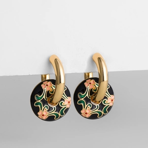 Goldene Creolen mit schwarzen Emaille-Anhängern und zarten floralen Motiven im Detail