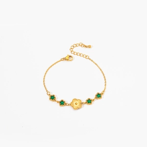 Detailed view of a gold-plated bracelet with green star stones and floral centerpiece