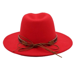 Detail of red wool felt fedora featuring a brown leather decorative band and bowtie