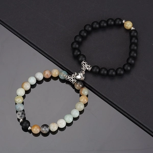 Macro detail of natural stone couple bracelets with a heart-shaped magnetic clasp
