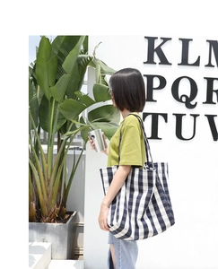 Close-up of a large canvas tote bag featuring a classic black and white checkered pattern