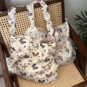 Close-up of vintage butterfly lace tote bag on a rustic rattan chair with detailed texture