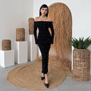 Détail d'une robe longue noire à épaules dénudées avec perles blanches et coupe ajustée