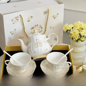 Detail of camellia and cat ceramic tea set with pot and cups in a yellow gift box