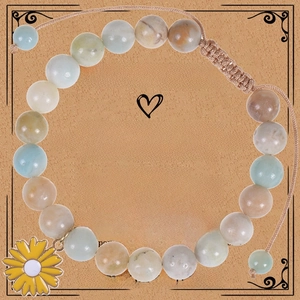 Detail of natural stone beaded bracelet with yellow sunflower charm on a gift card