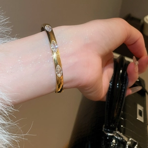 Detailed view of a gold bangle set with three sparkling marquise-cut zircon stones